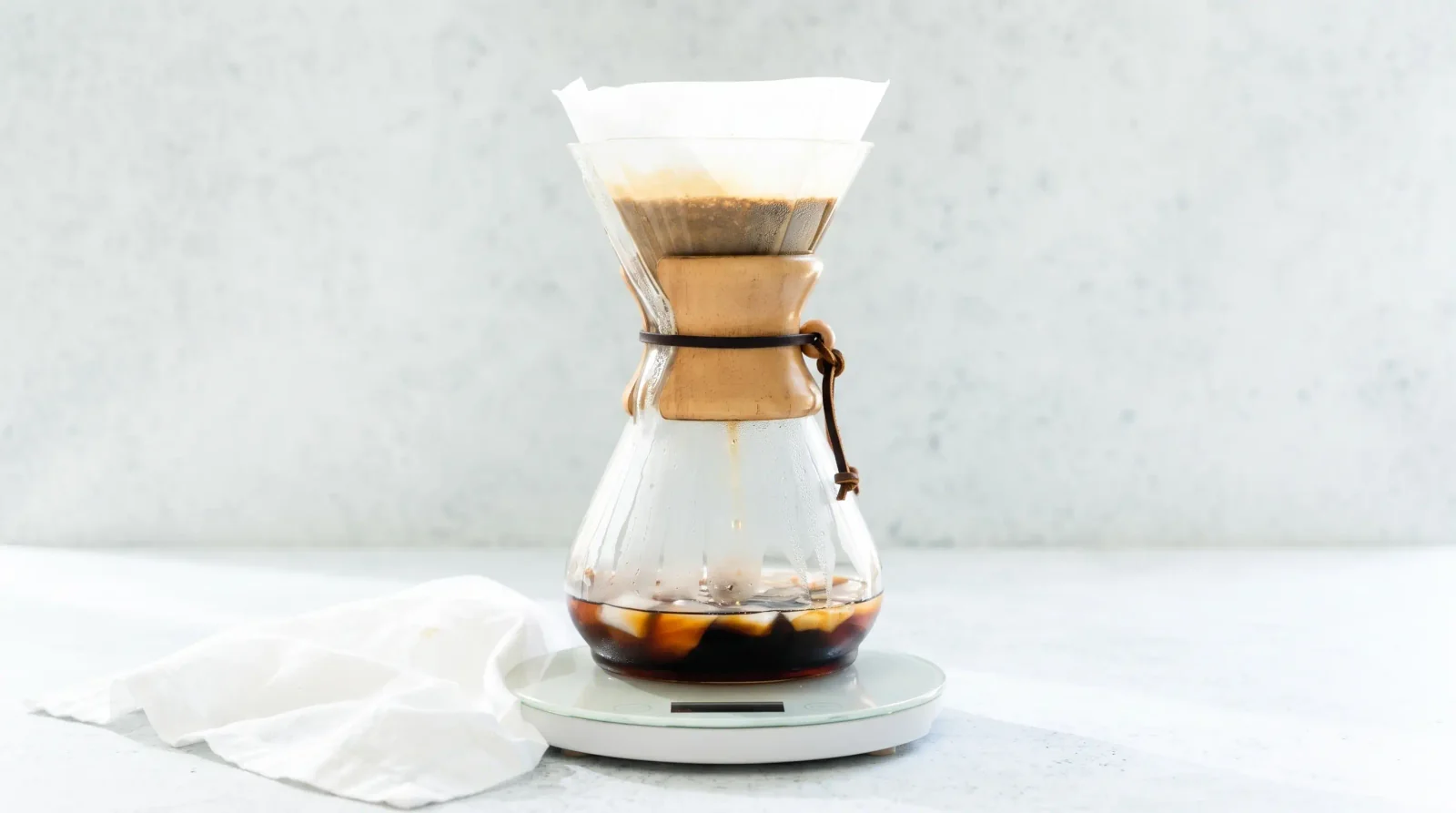 Ice shifting inside a Chemex as coffee streams down, high-key summer light.