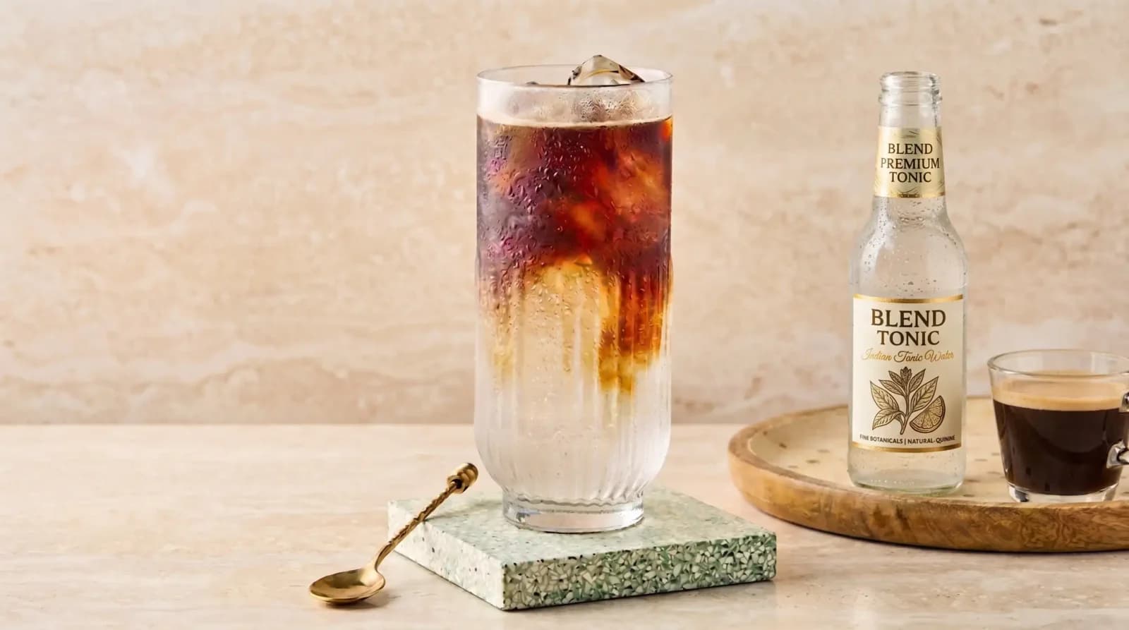 Tonic bubbles rising through espresso haze, lemon twist on the rim.