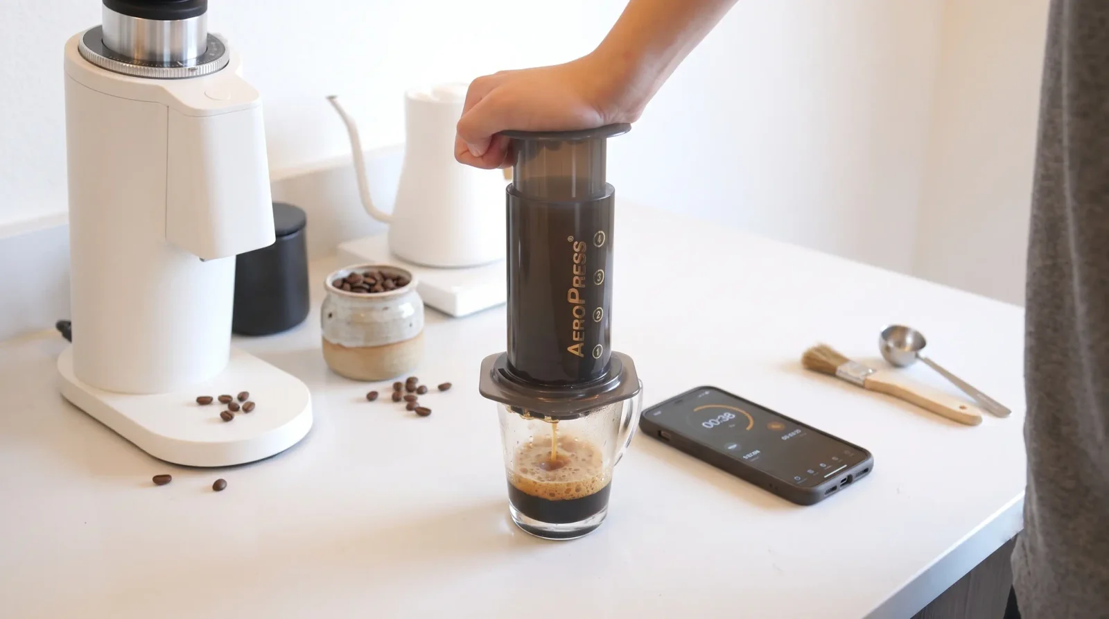 AeroPress on a diner mug, one hand mid-press, hazy kitchen morning.